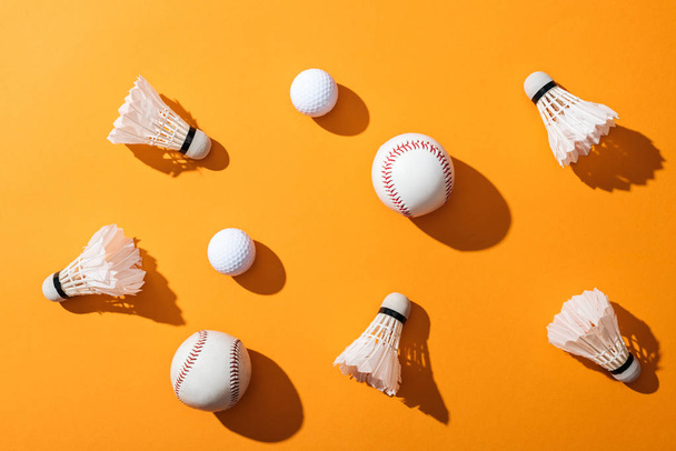 top view of shuttlecocks with feathers near softballs and golf balls on yellow  - Photo, Image