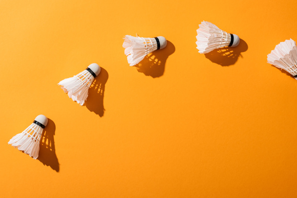 top view of white shuttlecocks with feathers on yellow  - Photo, Image
