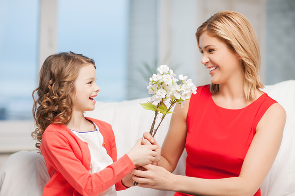 Happy mother and daughter with flowers - Фото, изображение