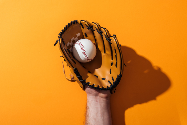 vista recortada del hombre sosteniendo softbol en guante de béisbol marrón en amarillo
  - Foto, Imagen