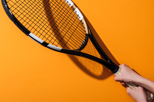 cropped view of sportive woman holding tennis racket on yellow  - Φωτογραφία, εικόνα