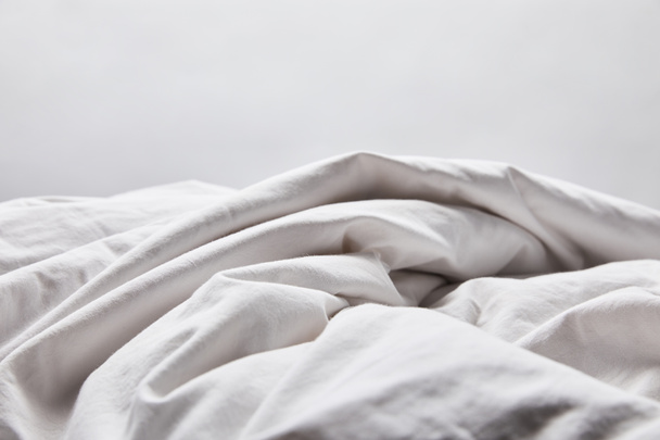 rypistynyt valkoinen huopa sängyssä eristetty harmaa
 - Valokuva, kuva