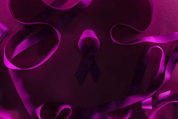 top view of purple ribbon rounded by other ribbons in shadow - Photo, Image
