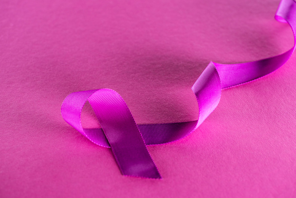 purple ribbon on pink background with shadow  - Foto, Imagen