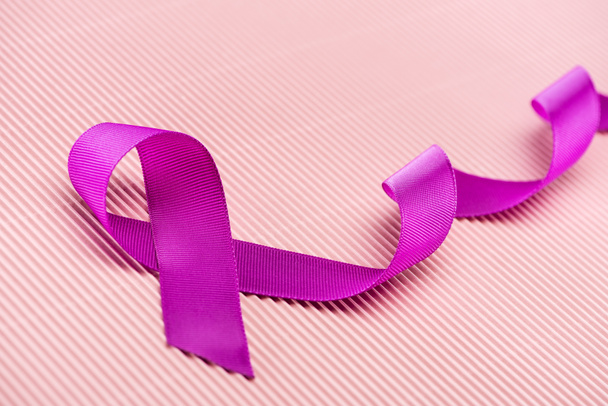 purple ribbon on pink background, violence concept - 写真・画像