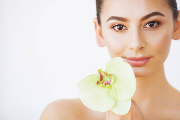 Ihonhoito. Nainen kauneus, kasvot ihonhoito ja muodostavat, tyttö orkidea kukka
 - Valokuva, kuva