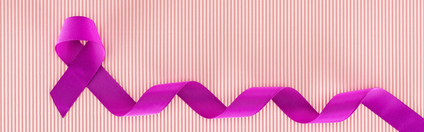 panoramische foto van paars lint op roze textuur achtergrond - Foto, afbeelding