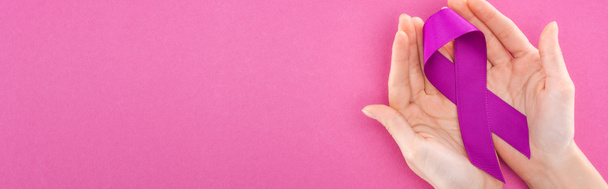 Panoramaaufnahme einer Frau mit lila Schleife, beide Hände isoliert auf rosa - Foto, Bild