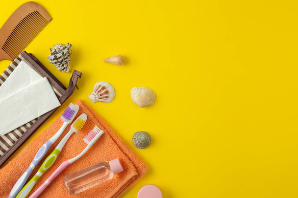 Una serie di cosmetici e prodotti per la cura personale per viaggiare in una borsa cosmetica su uno sfondo giallo brillante. vista dall'alto. cosmetici da viaggio
 - Foto, immagini