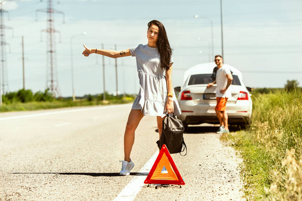 Young couple traveling on the car in sunny day - Фото, изображение
