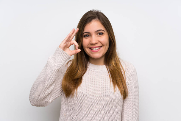 Young girl with white sweater showing an ok sign with fingers - Photo, Image