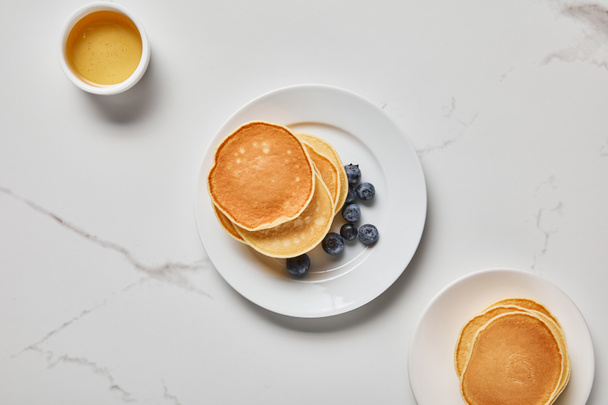 top view of bowl with honey near plates with pancakes  - Photo, Image