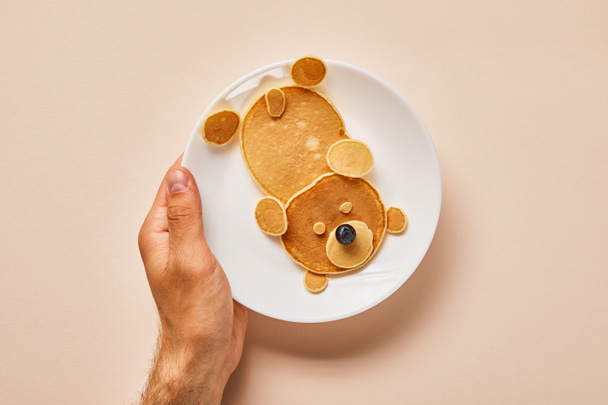 cropped view of pancakes on plate with one blueberry on pink, bear concept - Photo, Image