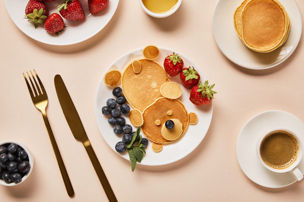 Top uitzicht van pannenkoeken met bessen, honing en kopje koffie, Bear concept - Foto, afbeelding