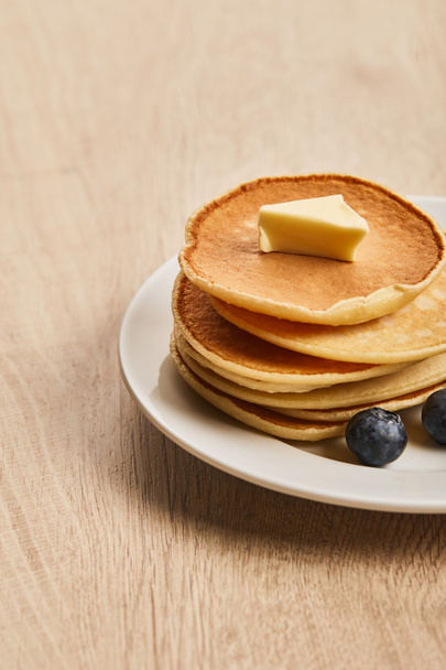 pancakes with butter and blueberries on plate on wooden surface  - Valokuva, kuva