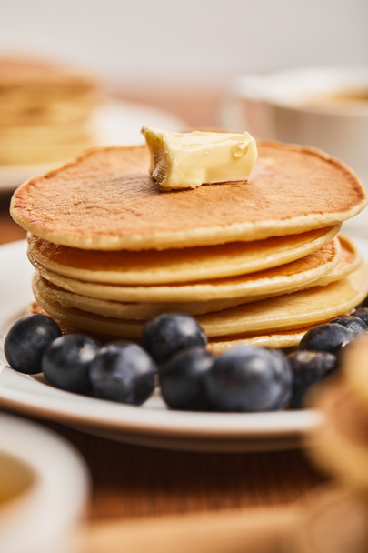 selective focus of pancakes with butter and blueberries on white plate  - 写真・画像