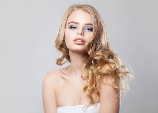 Блондинка. Молодая женщина с длинными светлыми волосами и макияжем
 - Фото, изображение