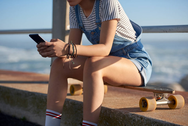 Młoda kobieta za pomocą telefonu tekstylna zewnątrz  - Zdjęcie, obraz