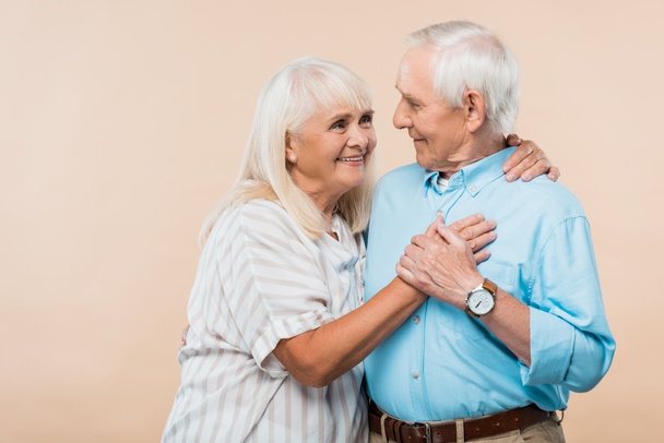 onnellinen eläkkeellä oleva nainen katselee iloinen vanhempi mies eristetty beige
  - Valokuva, kuva