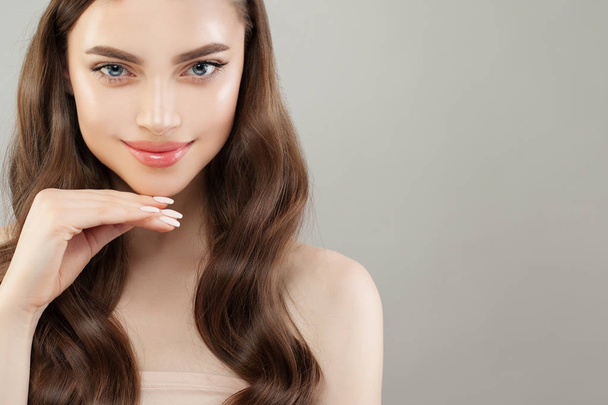 Woman face. Pretty model with clear skin, long hair and manicure nails - Foto, imagen
