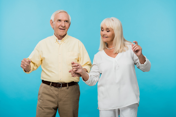 feliz casal aposentado com cabelo gestual cinzento isolado em azul
  - Foto, Imagem