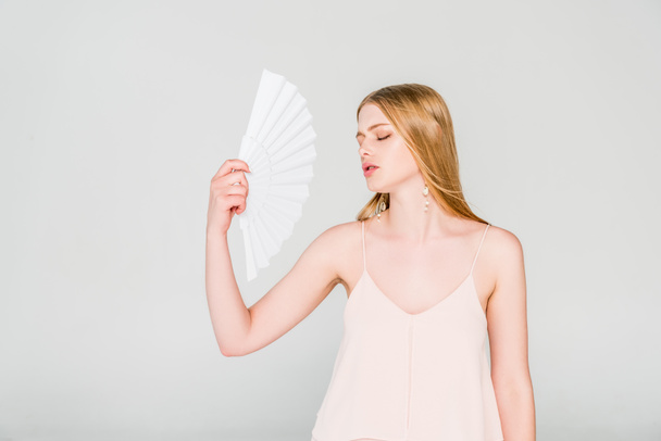 beautiful young woman with hand fan suffering from heat on grey - Foto, Bild