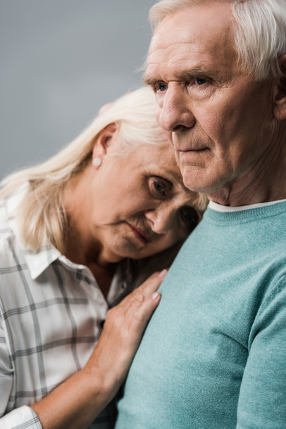 sad retired man near frustrated senior wife looking at camera isolated on grey  - Foto, immagini