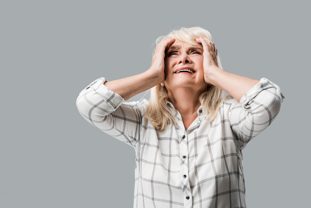 upset retired woman with grey hair touching head isolated on grey  - Фото, зображення