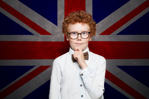 Pensando niño estudiante contra el fondo de la bandera del Reino Unido
.  - Foto, imagen