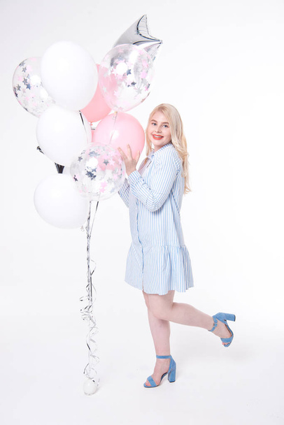 Full length portrait of a joyful young woman, rejoices and celebrates on a white background with multi-colored balloons. - Fotografie, Obrázek