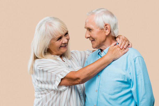 happy retired woman hugging senior husband isolated on beige  - Fotoğraf, Görsel