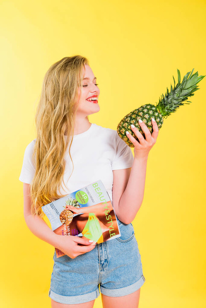 beautiful girl with beauty and style magazine and pineapple Isolated On yellow - Φωτογραφία, εικόνα