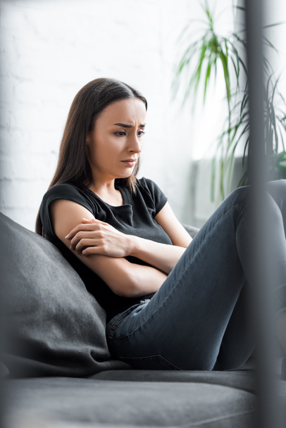 ソファに座ってうつ病に苦しむ若い女性を泣く選択的な焦点 - 写真・画像