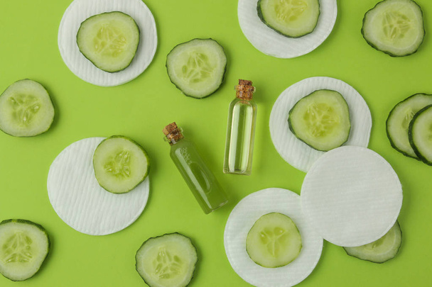 Cosmetics care with cucumber extract and fresh cucumber on a bright green background. spa. beauty. - Φωτογραφία, εικόνα