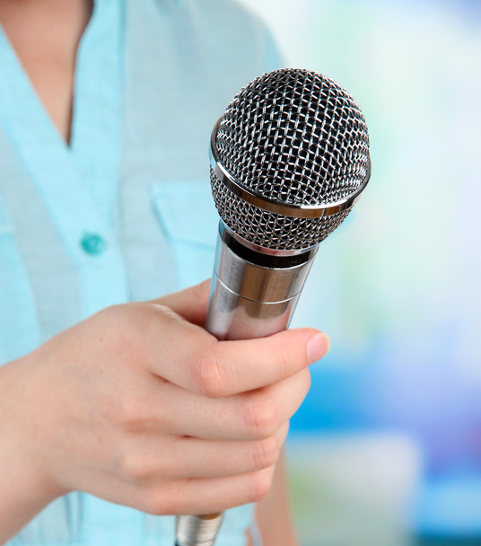 Female with microphone on room background - Foto, afbeelding