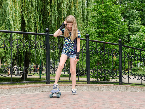 Happy girl rides on a skateboard  - Fotó, kép
