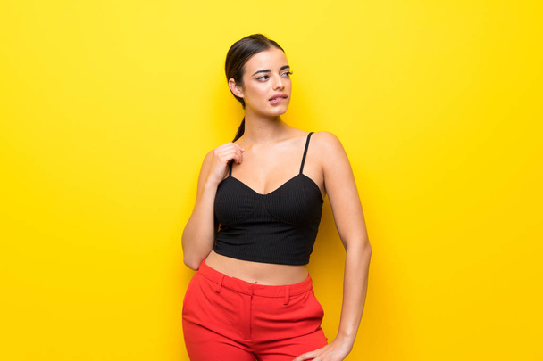 Young woman over isolated yellow background with confuse face expression - Photo, Image