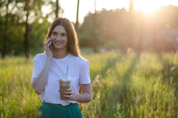 A young girl with a coffee cocktail. Summer image. - Фото, изображение