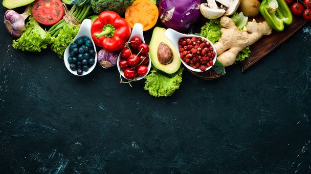 Fresh vegetables and fruits on a black background. Vitamins and minerals. Top view. Free space for your text. - Zdjęcie, obraz