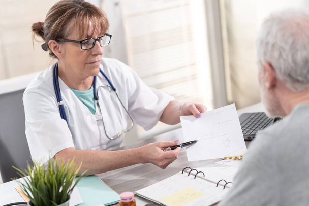 Vrouwelijke arts voorschrift geven haar patiënt - Foto, afbeelding