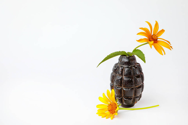 yellow flowers in hand grenade on white background - Photo, Image