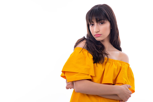 Retrato del atractivo modelo femenino joven. La chica posa con un vestido amarillo en un estudio con un fondo blanco
. - Foto, Imagen