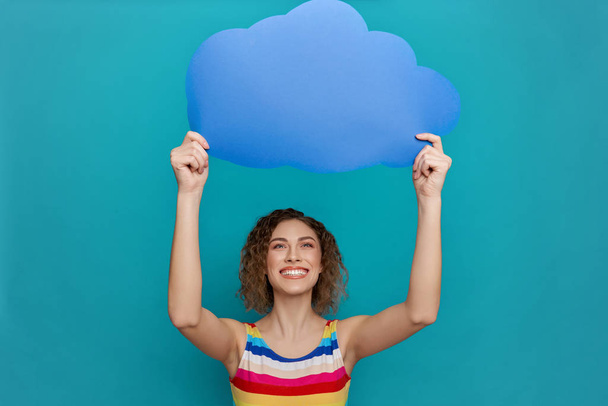 Girl holding speech bubble in form of cloud above head. - Fotó, kép