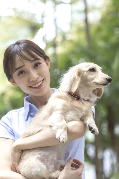 Joven mujer asiática con perro en la calle
 - Foto, imagen