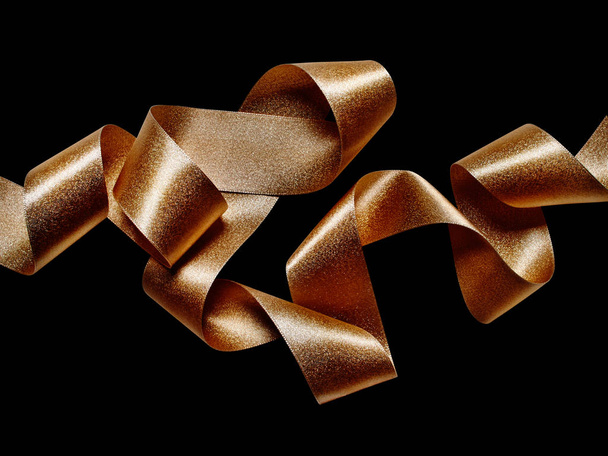 Close up of gold bronze metallic ribbon isolated on black backgr - Photo, Image