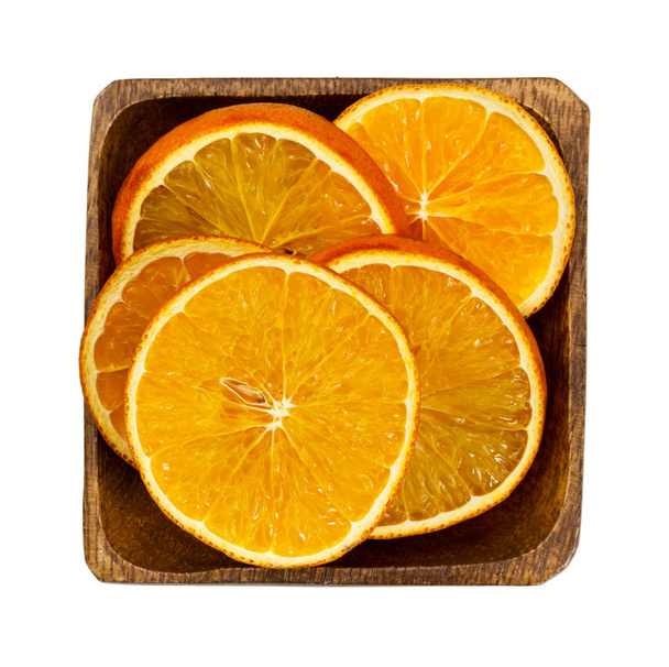 Сушені апельсинові скибочки в дерев'яній мисці
  - Фото, зображення
