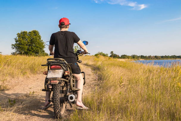 Montar una motocicleta paralela al río en busca de una nueva ruta
 - Foto, imagen