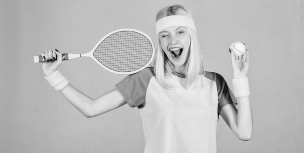 Sport for maintaining health. Active leisure and hobby. Athlete hold tennis racket in hand on grey background. Tennis sport and entertainment. Tennis club concept. Girl adorable blonde play tennis - Photo, Image