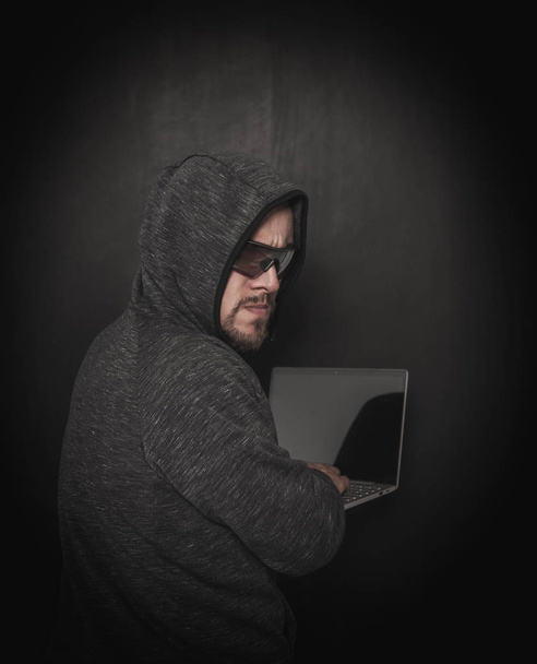 Man hacker programmeur met behulp van laptop op Dark  - Foto, afbeelding