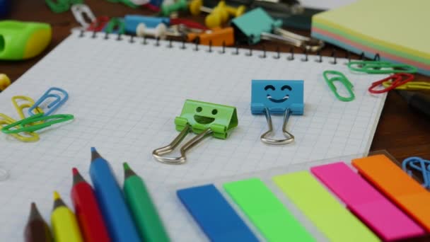 Sonrisas clips de encuadernación azul y verde en el cuaderno con suministros de oficina de la escuela
 - Metraje, vídeo